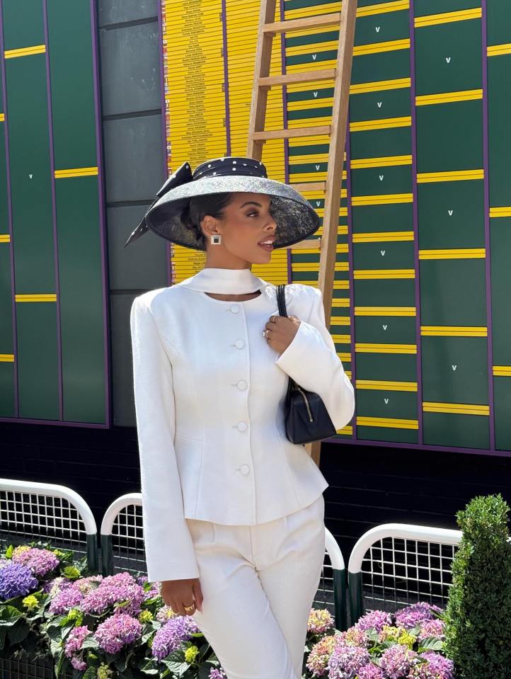 Woman in white suit and large hat at Wimbledon.