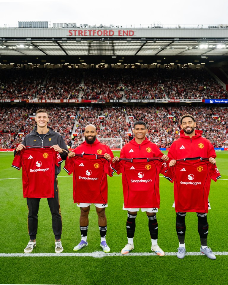 Four new Manchester United players holding up their team shirts.