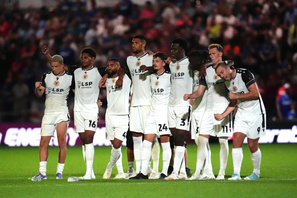 Bromley football players react during a penalty shootout.