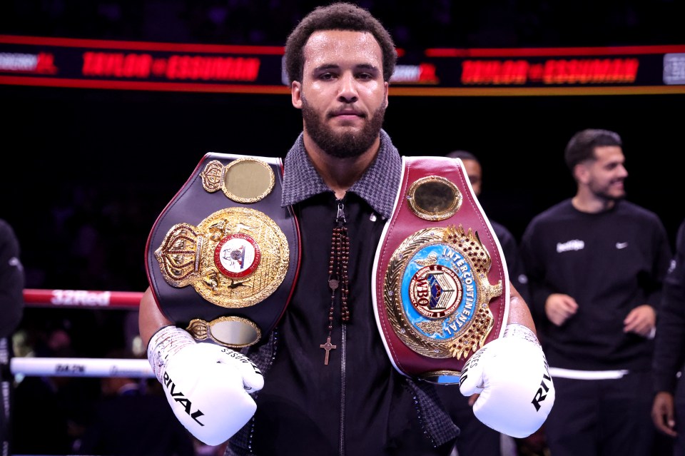 Moses Itauma holding two championship boxing belts.