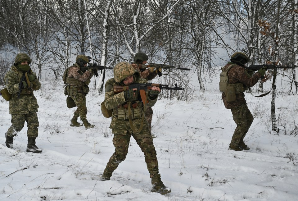 Ukrainian soldiers conducting a field training exercise in a snowy forest.