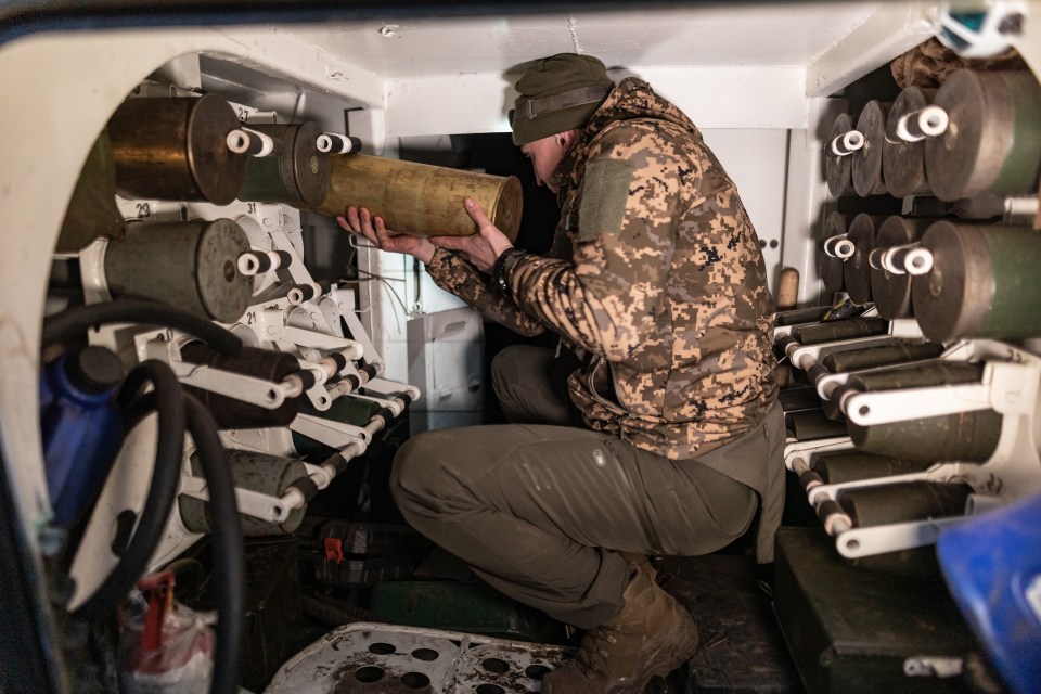 Ukrainian soldier loading artillery shells.