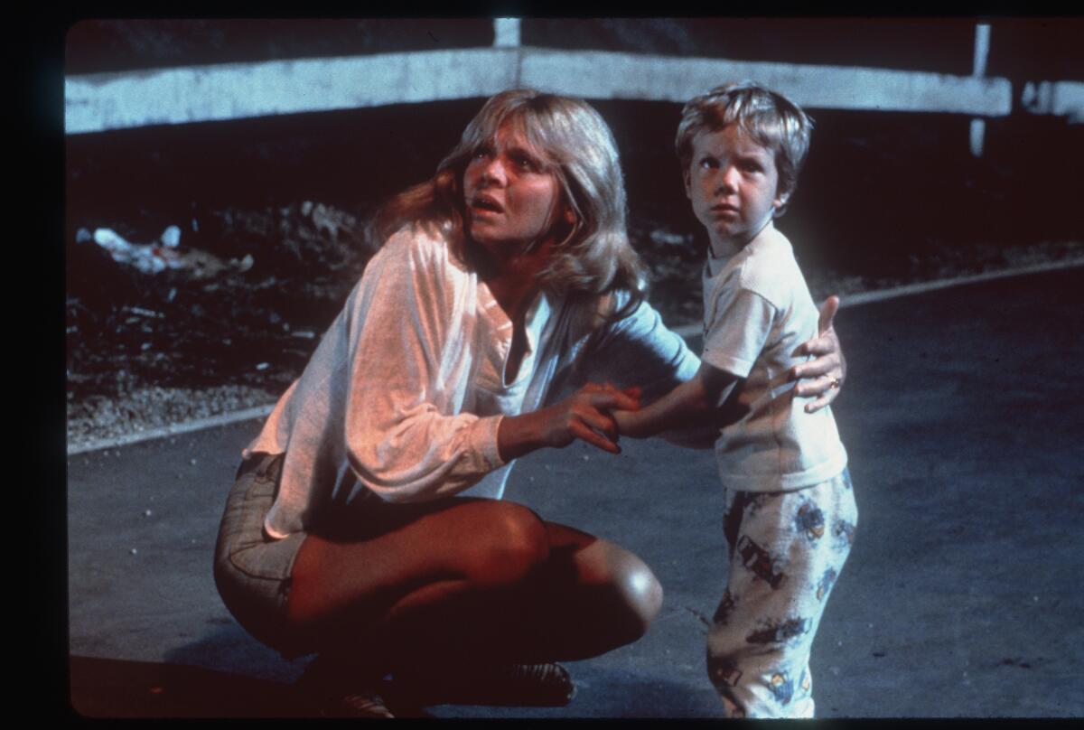 A woman and a boy look up into the night sky.