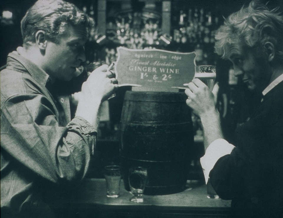 Black and white photo of Michael Caine and Terence Stamp drinking in a pub.