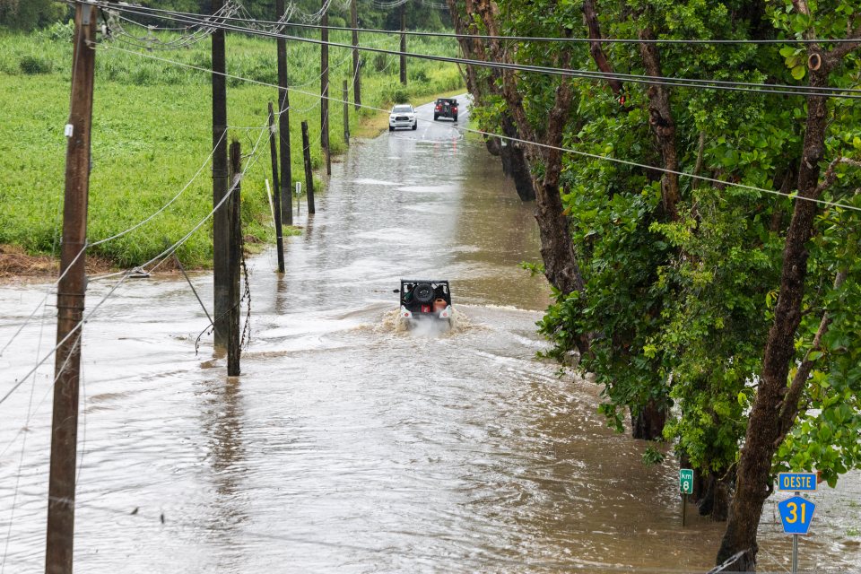 Vehicles driving through a flooded road in Naguabo, Puerto Rico.