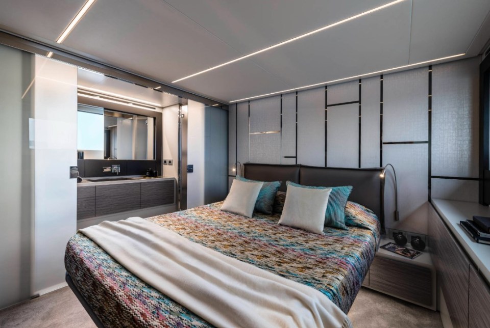 Pershing 6X yacht stateroom with bed and ensuite bathroom.