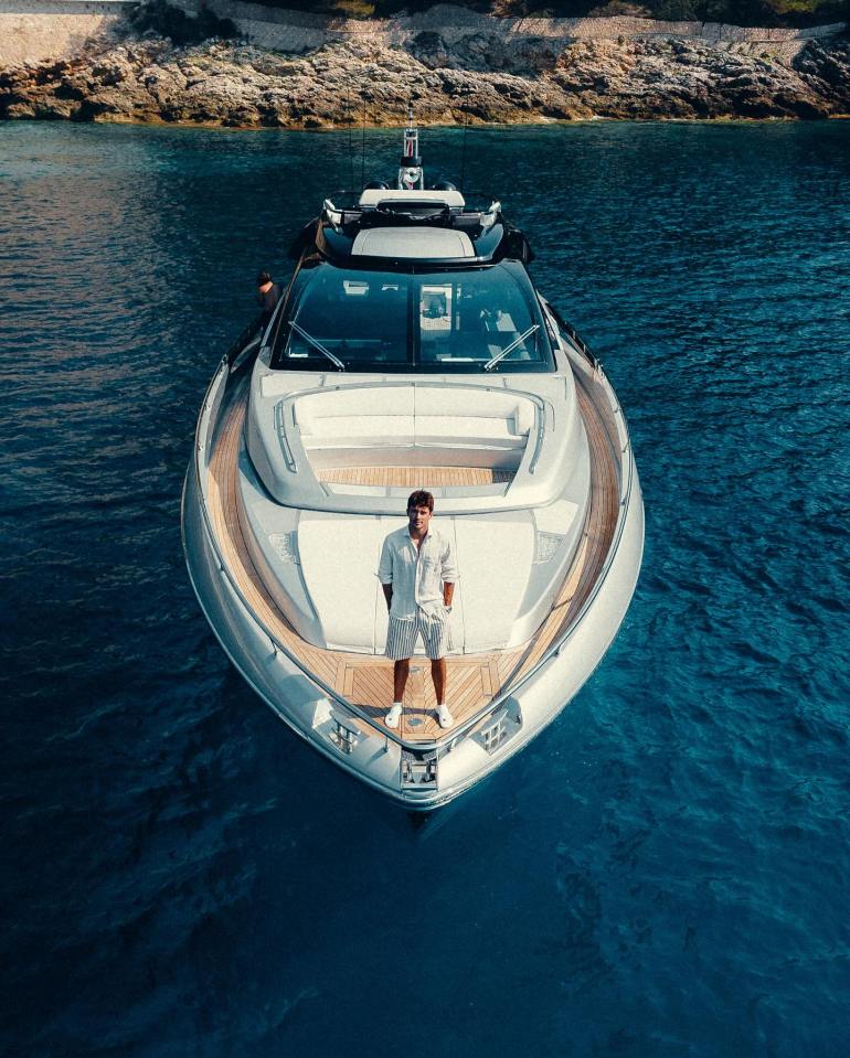 Man standing on the bow of a Riva yacht.