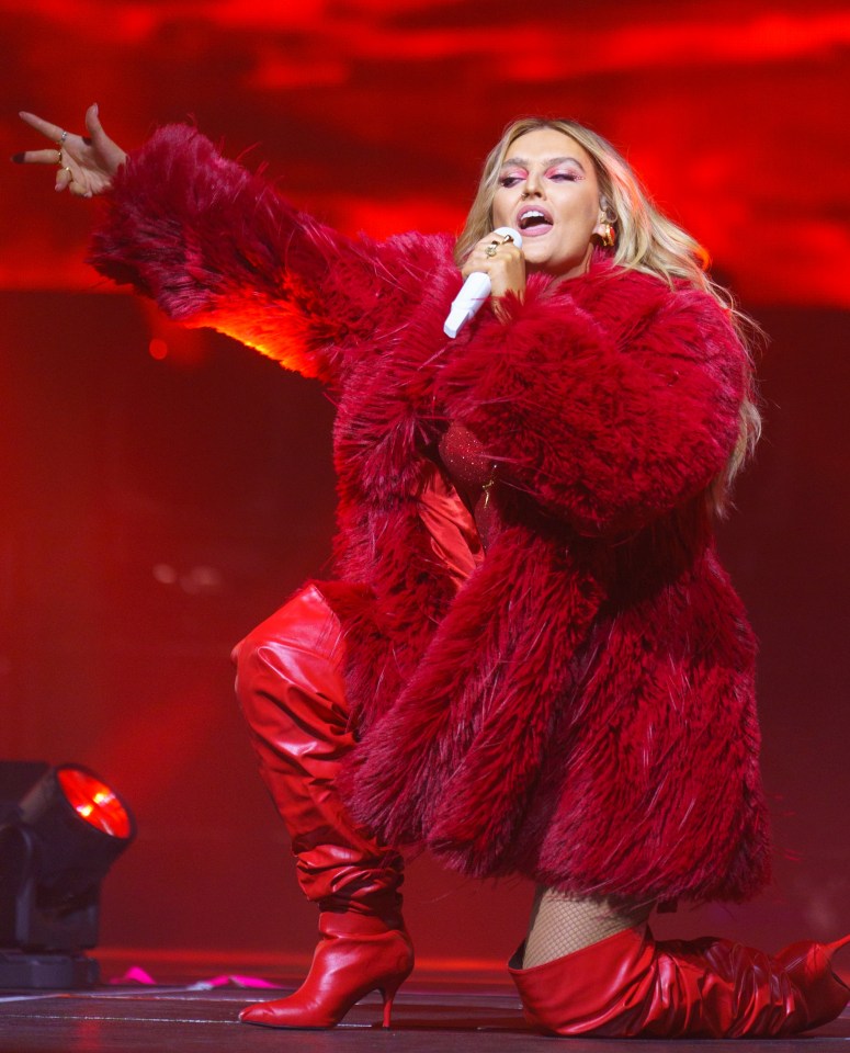 Perrie Edwards performing on stage.