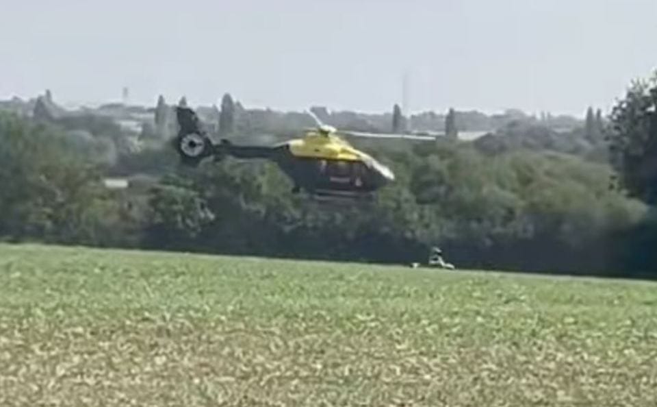 Helicopter flying low over a field.