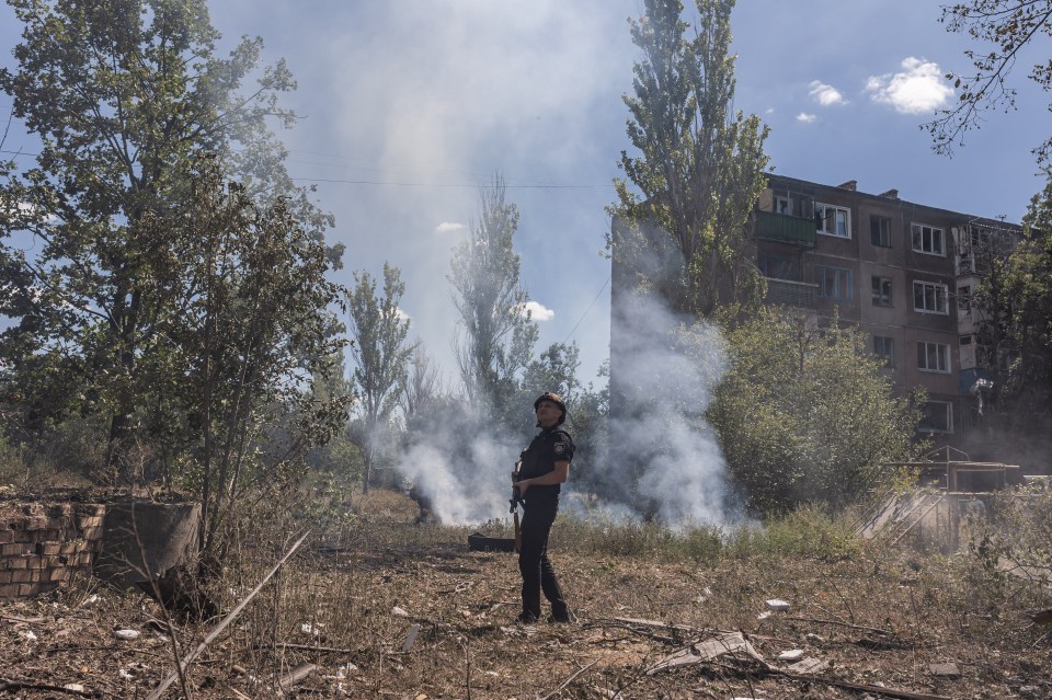 Ukrainian firefighter amidst smoke and debris after a Russian airstrike.