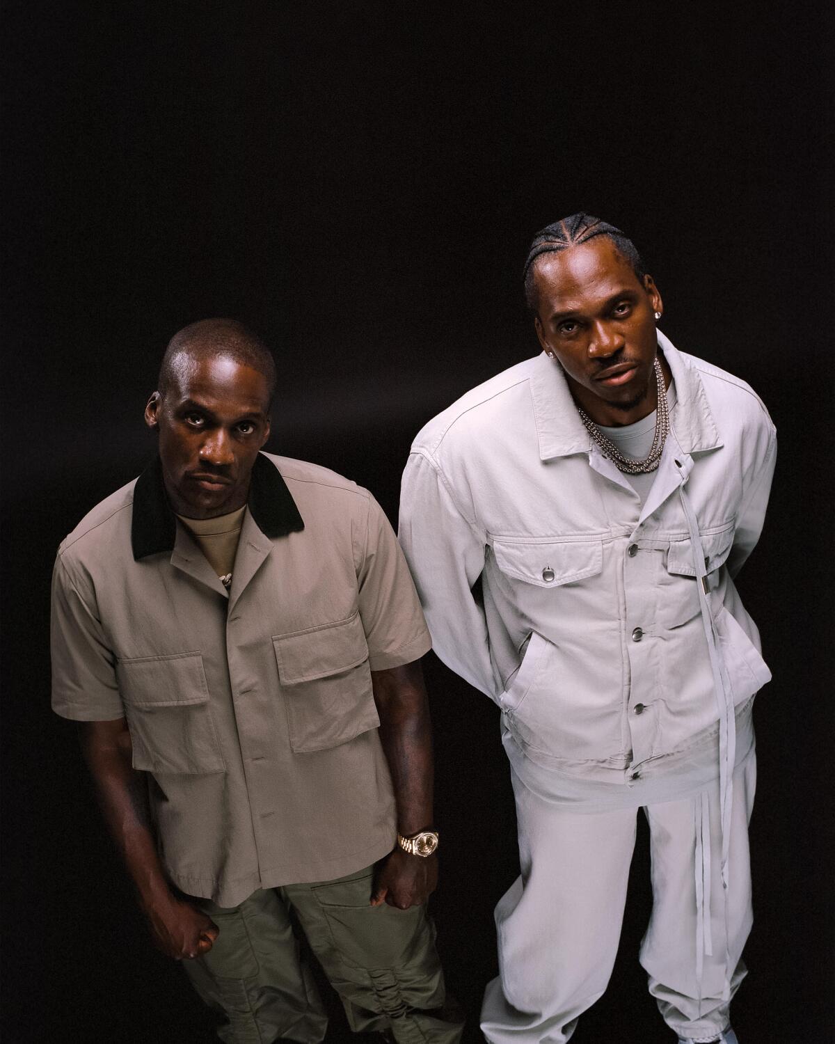 Malice, left and dressed in a tan shirt, and Pusha T, right and dressed in all white, of Clipse, pose for the camera.
