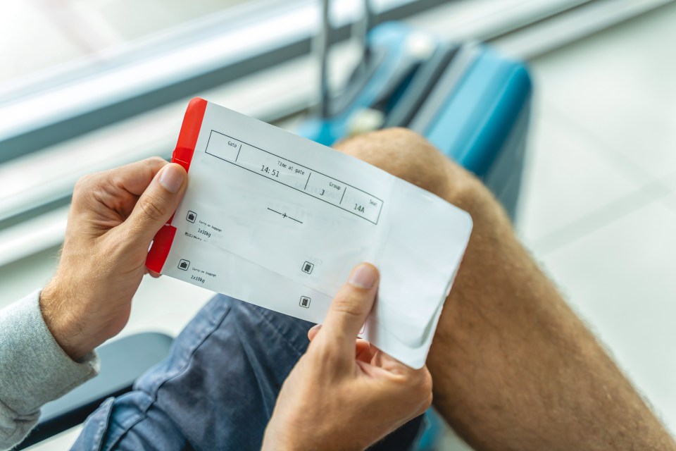 Man holding airline boarding pass.