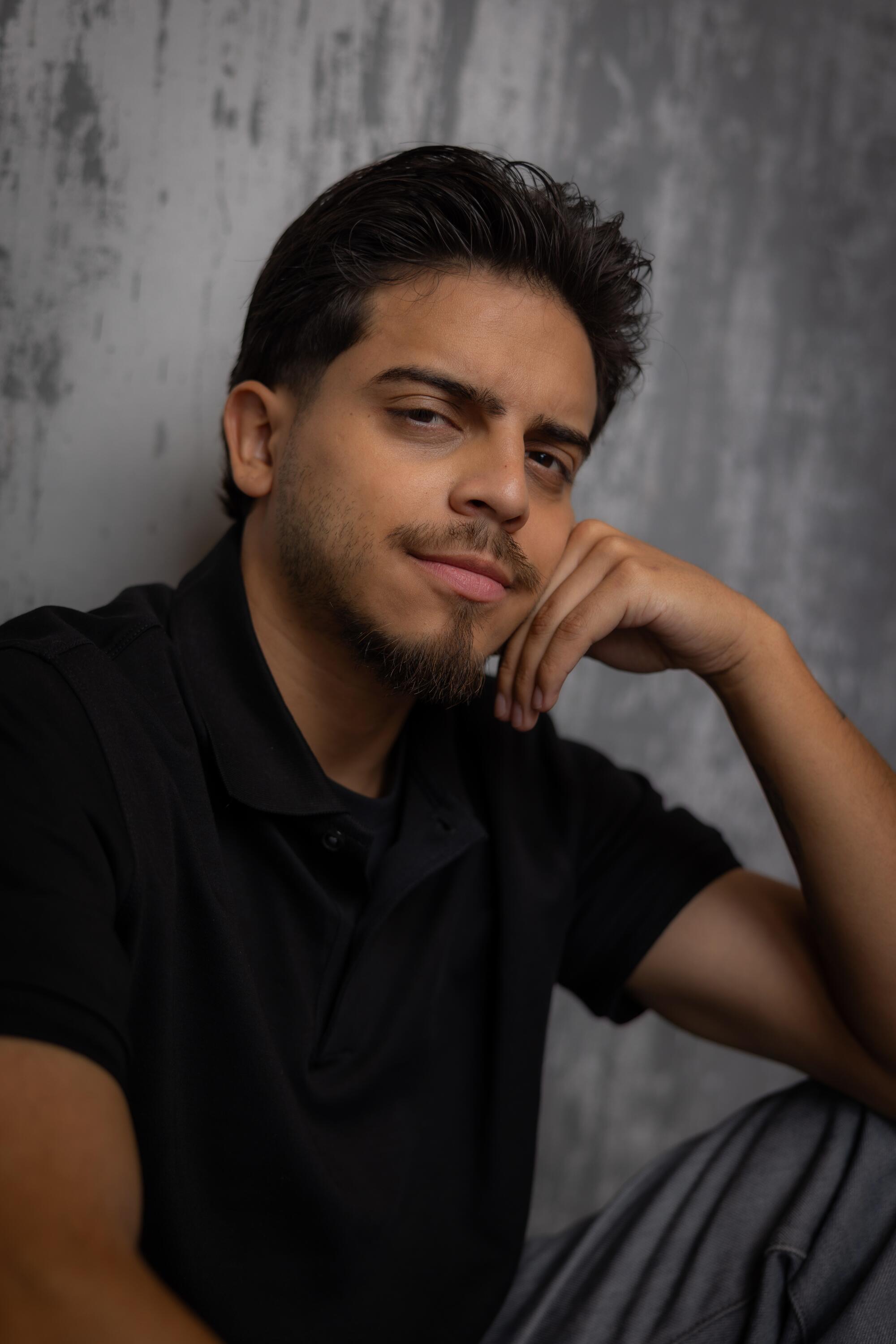 Man with elbow on his knee staring into the camera