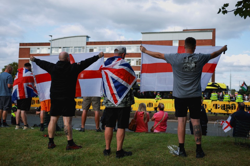 Anti-immigration protesters holding Union Jack and England flags.