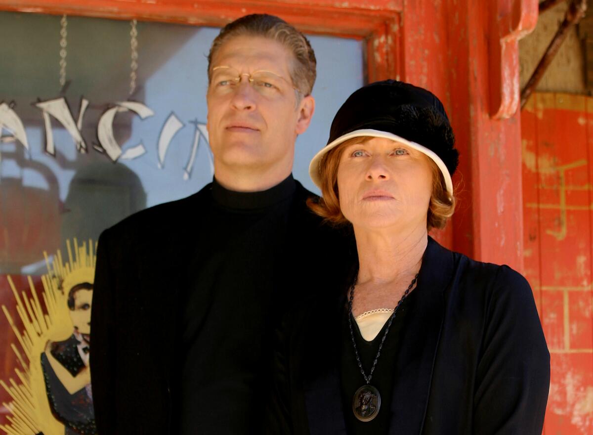 A man and woman dressed in black stand beside each other
