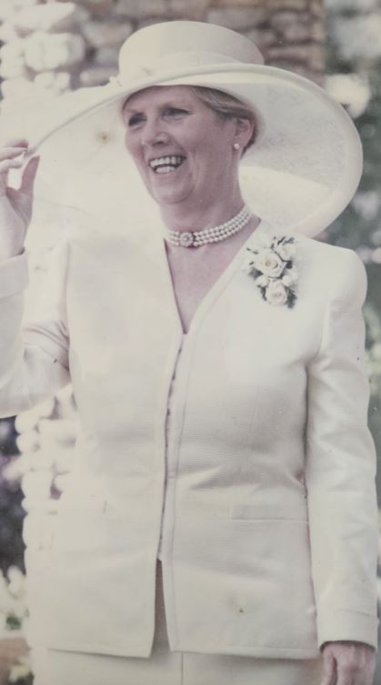 Photo of Ruth Parry in a white suit and hat.