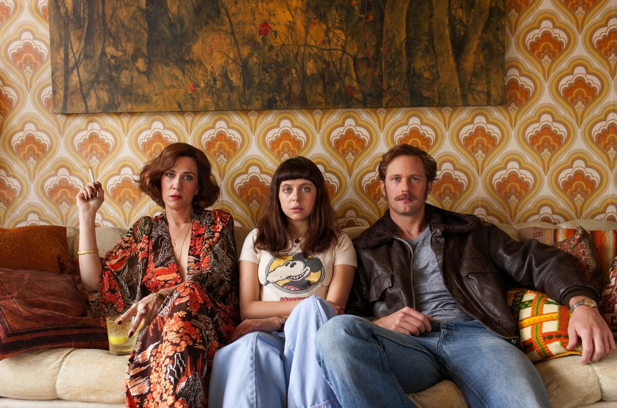 A family sits nervously on a couch together.