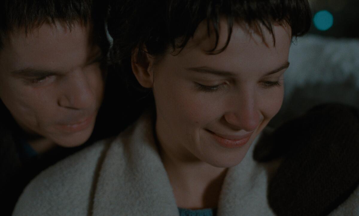 A man embraces a woman from behind.