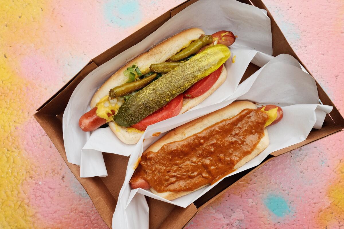 A Chicago dog, top, with a signature Cupid dog with chili, mustard and onions at Cupid's Hot Dogs in Winnetka.