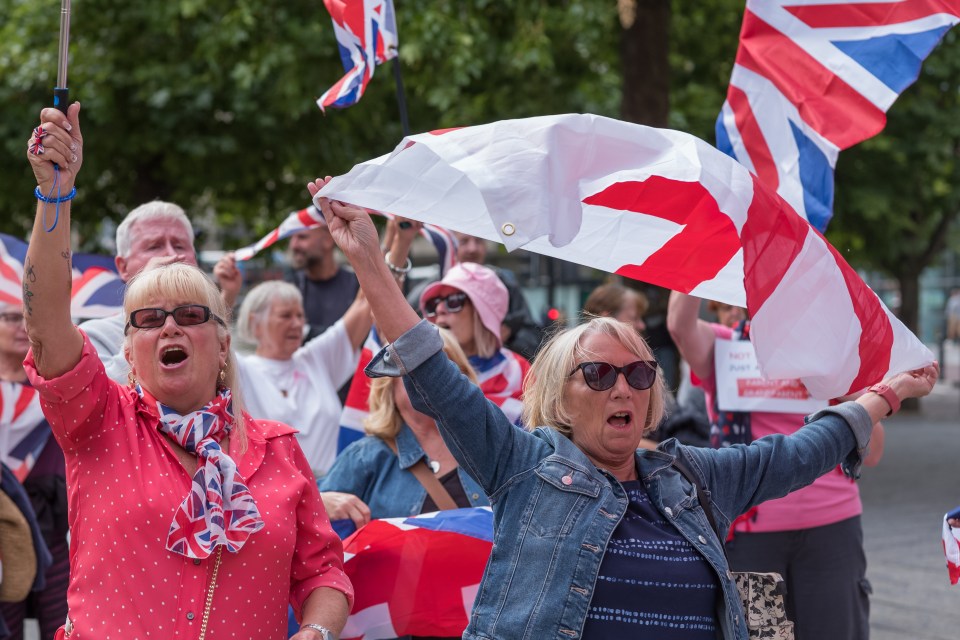 Anti-immigration protesters in Newcastle upon Tyne, England, waving Union Jack flags.