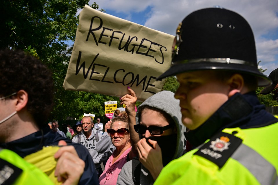Protestor holding a "Refugees Welcome" sign.