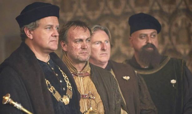 A group of men stand in a line and look serious