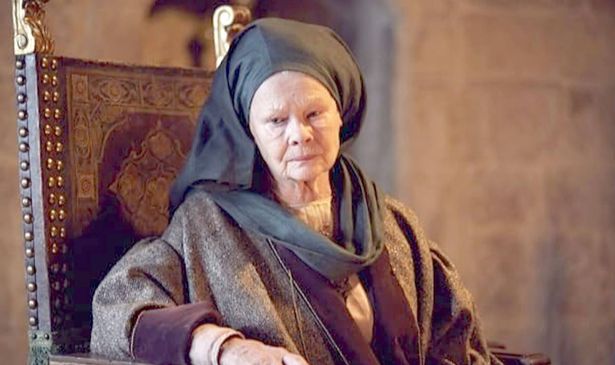 A woman in a black headdress sits on a chair