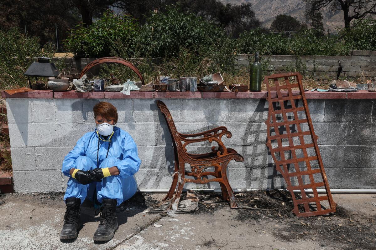Tami Outterbridge, daughter of artist John Outterbridge, sifts through the ashes of her father's home in Altadena.