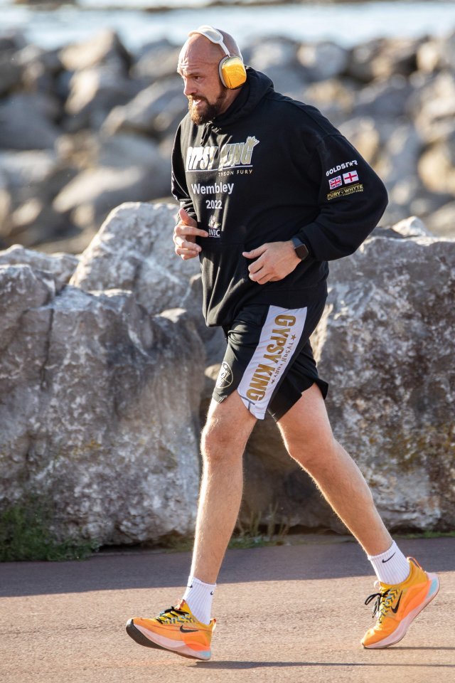 Tyson Fury jogging along a promenade.