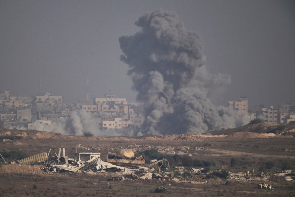 Smoke rises over destroyed buildings following an airstrike in Gaza.