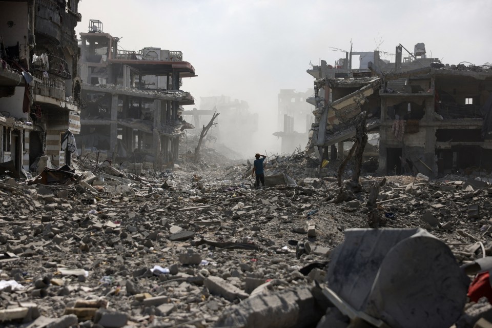 A young person stands amidst the rubble of destroyed buildings in Gaza.