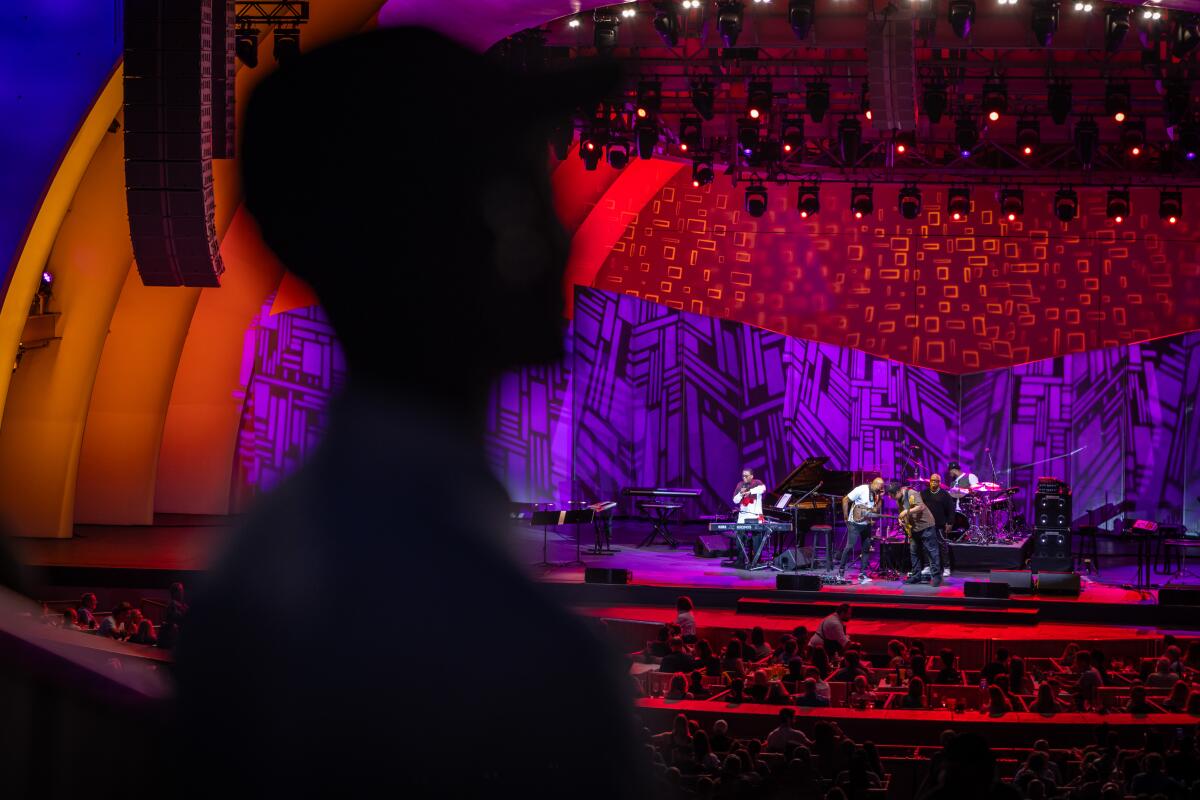 A shadowy figure of Tyrone Huntley listens to Herbie Hancock perform.