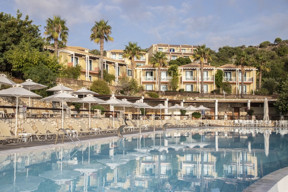Resort pool and buildings reflected in the water.