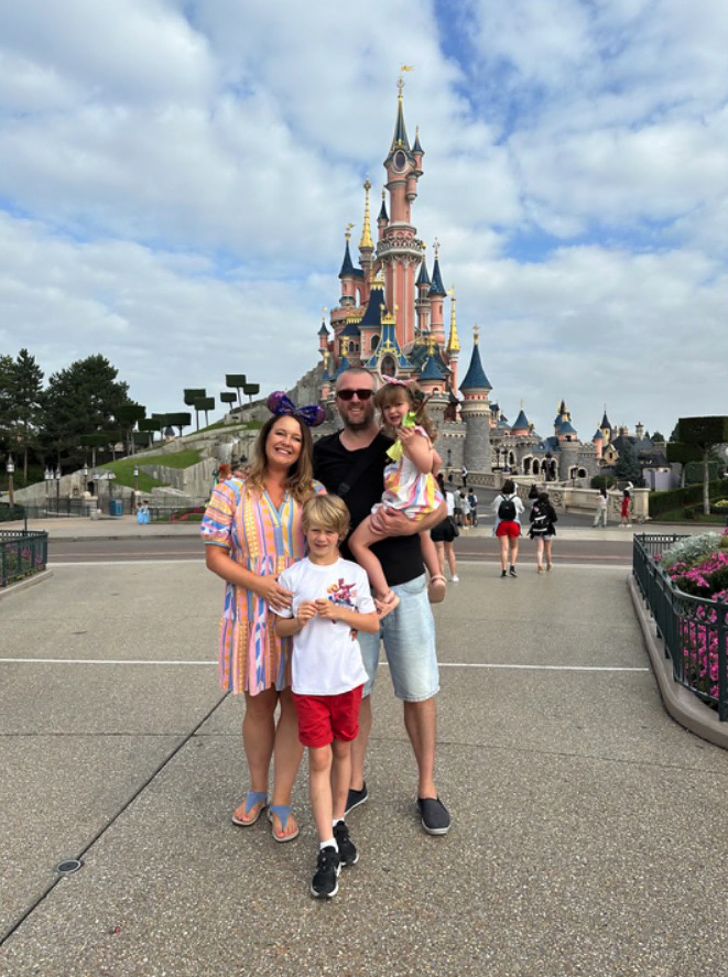 Family in front of Sleeping Beauty Castle at Disneyland Paris.