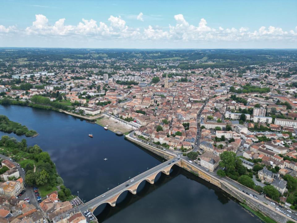 Aerial view of Bergerac, France, showing the Dordogne River and a bridge.