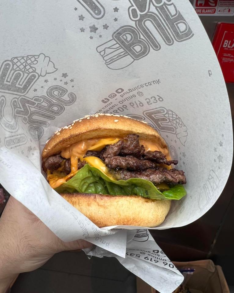 Cheeseburger in branded paper wrapper.