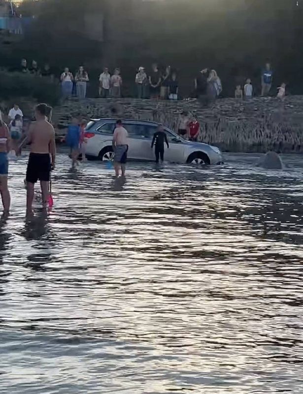 People attempting to rescue one of the cars