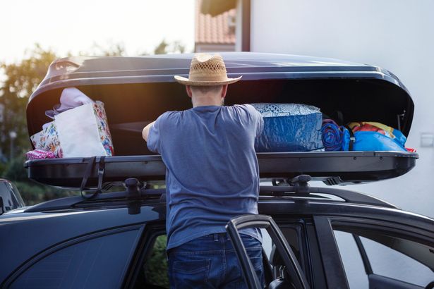 Man loading extra overhead storage of a car