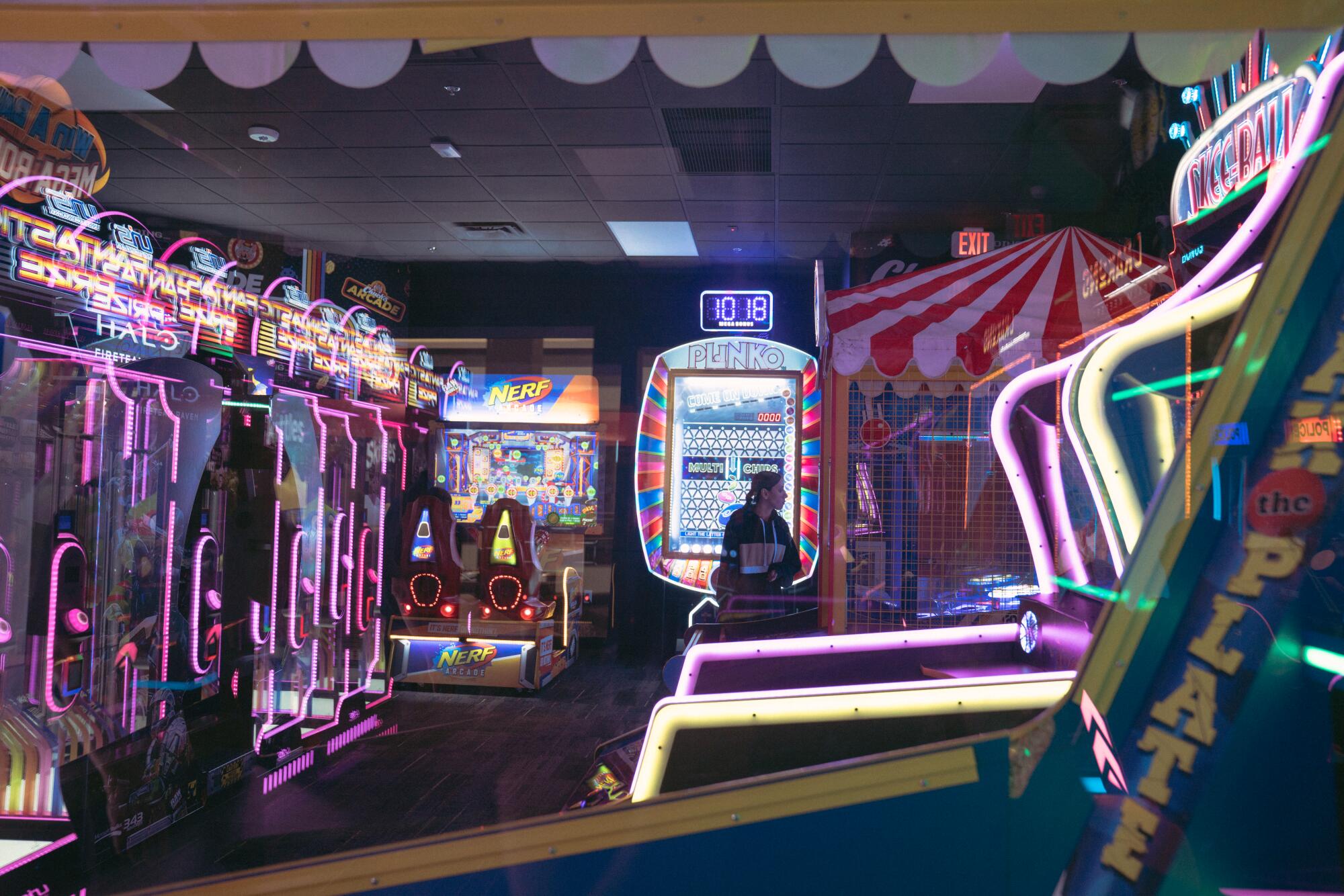 A person plays games in a row of Skee-Ball machines.
