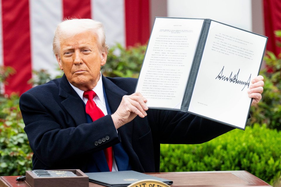 President Trump holding a signed executive order.