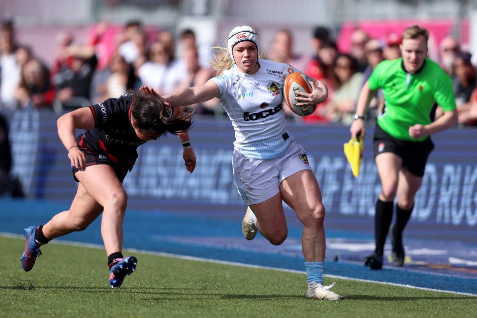 Jodie Ounsley of Exeter Chiefs running with the rugby ball, being challenged by an opponent.