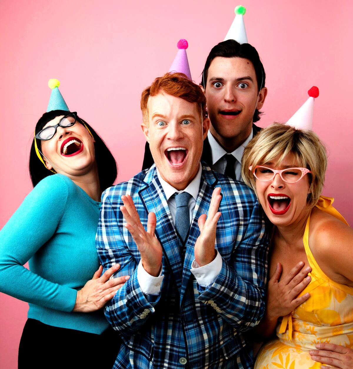 Four actors wearing part hats laughing.