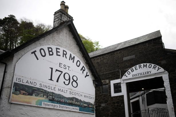 A picture shows signs at the entrance to Tobermory Distillery in Tobermory, the Isle of Mull,