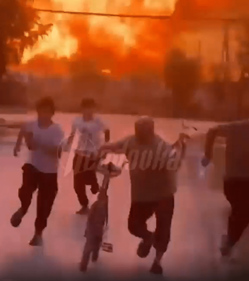 People fleeing a large fire.