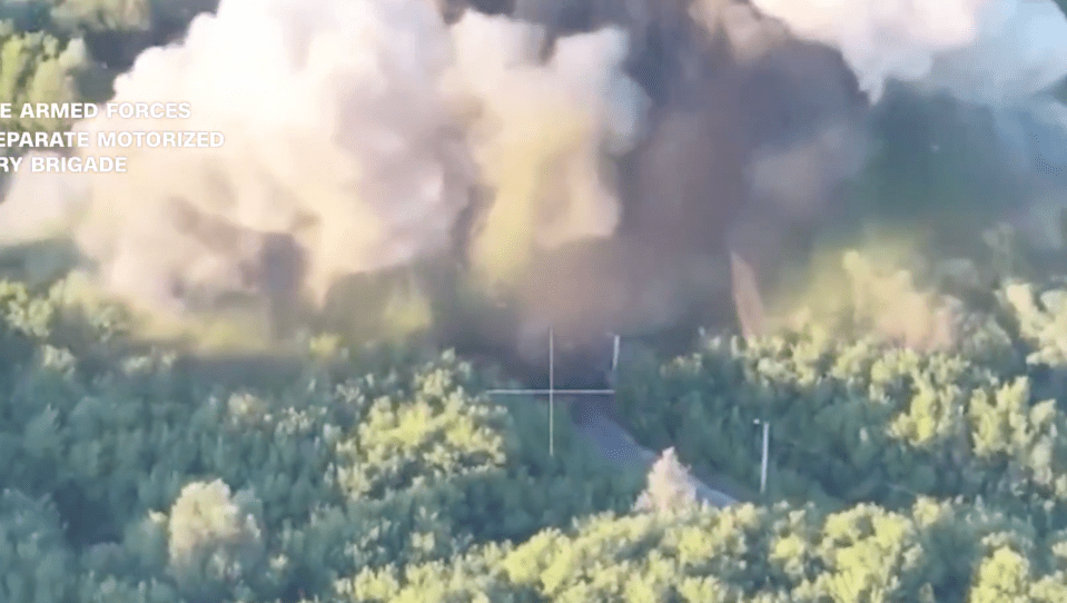 Aerial view of an explosion in a wooded area.