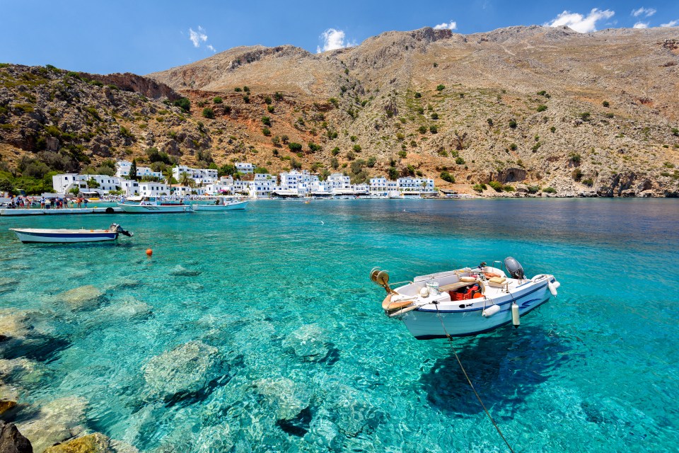Small motorboat in clear water bay near Loutro town, Crete.