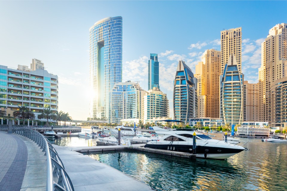 Dubai Marina skyline with yachts docked.