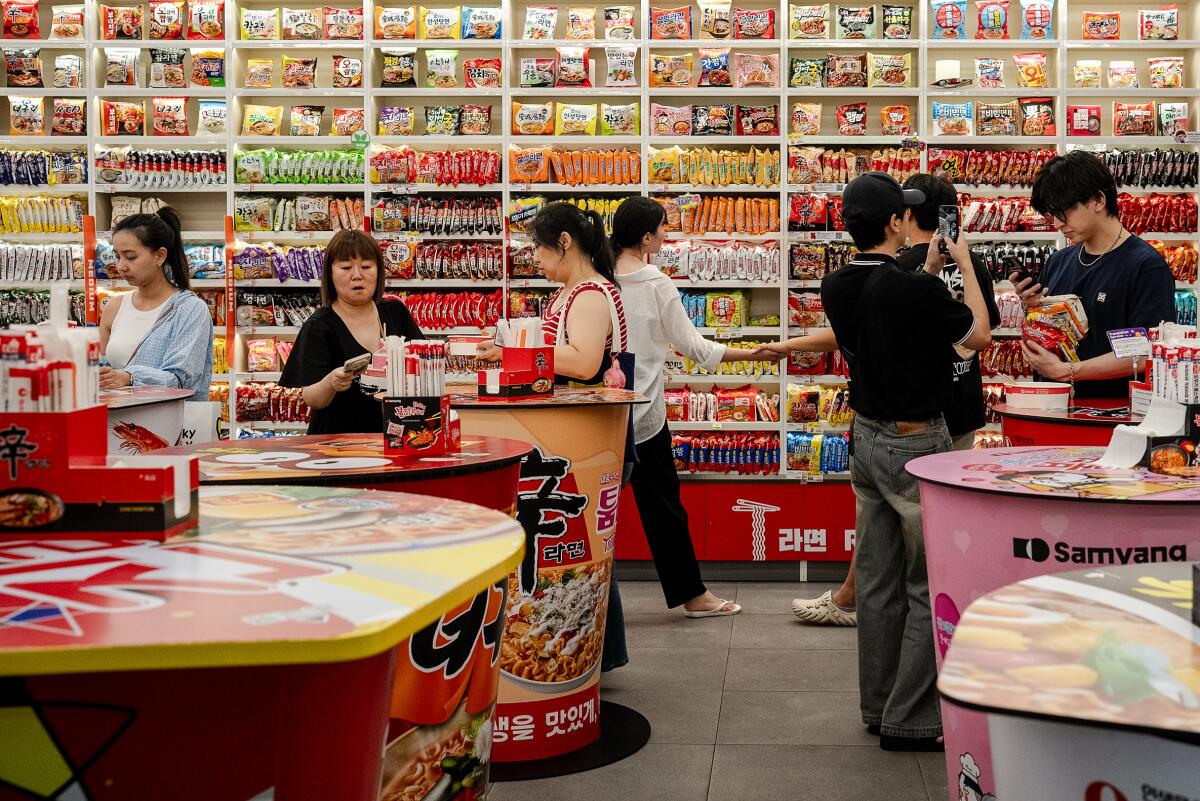 People shop and eat among tables at the colorful CU Ramyun Library store