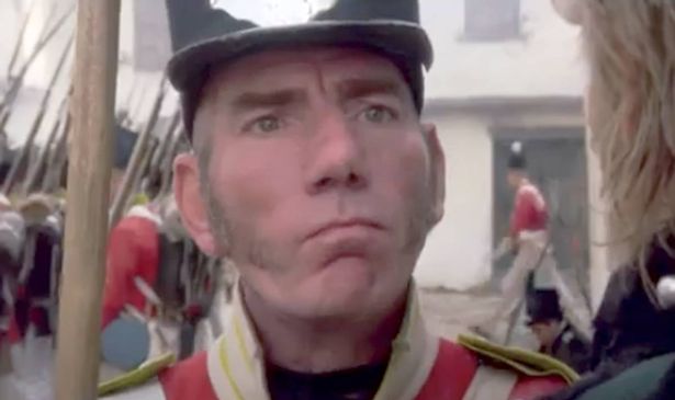 A man in a soldier’s outfit looks serious