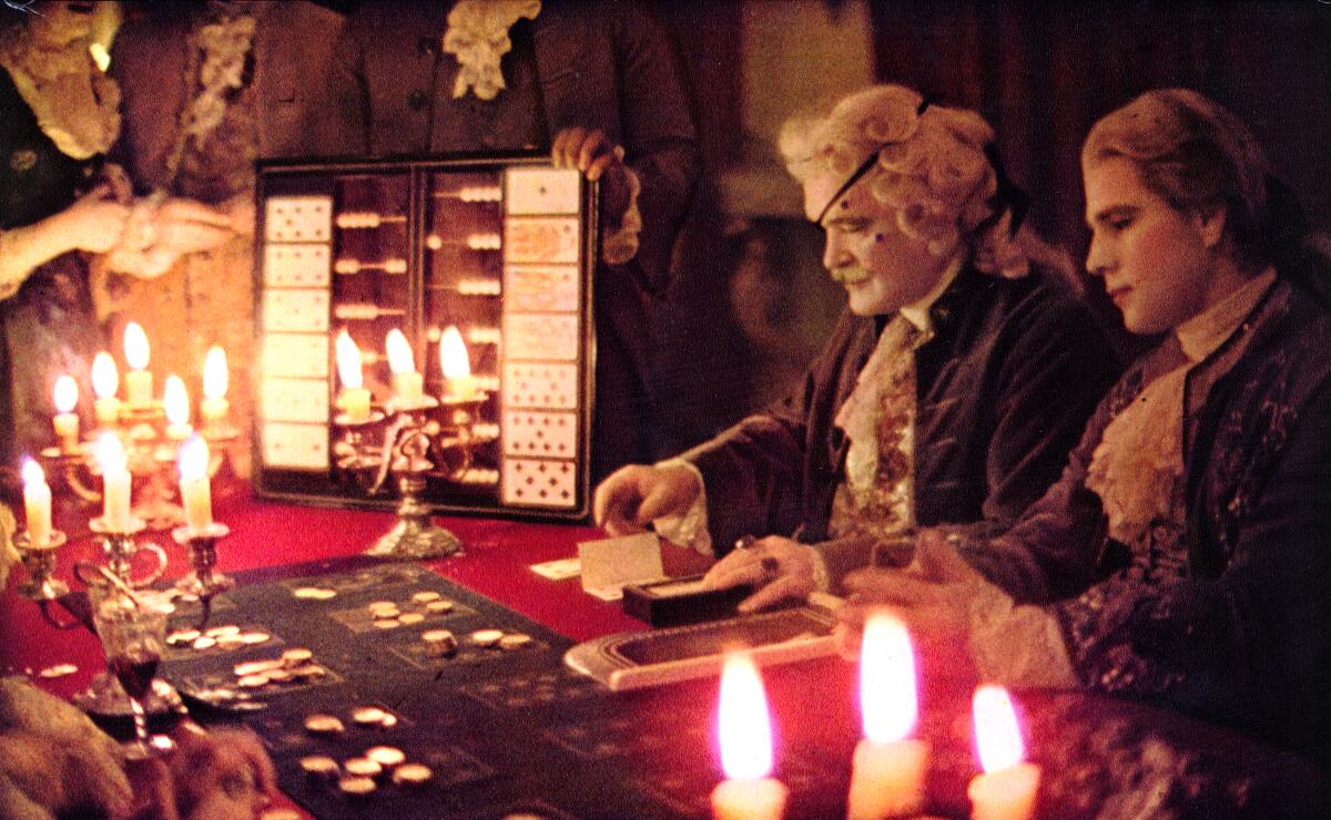 Two fancy card dealers entertain at a royal gambling table.